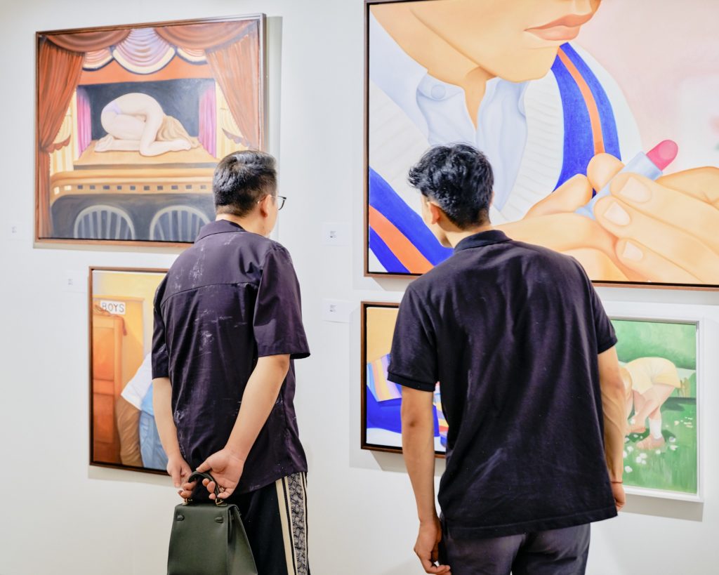 Two men look at paintings