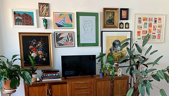 A selection of framed artworks displayed in a gallery wall style