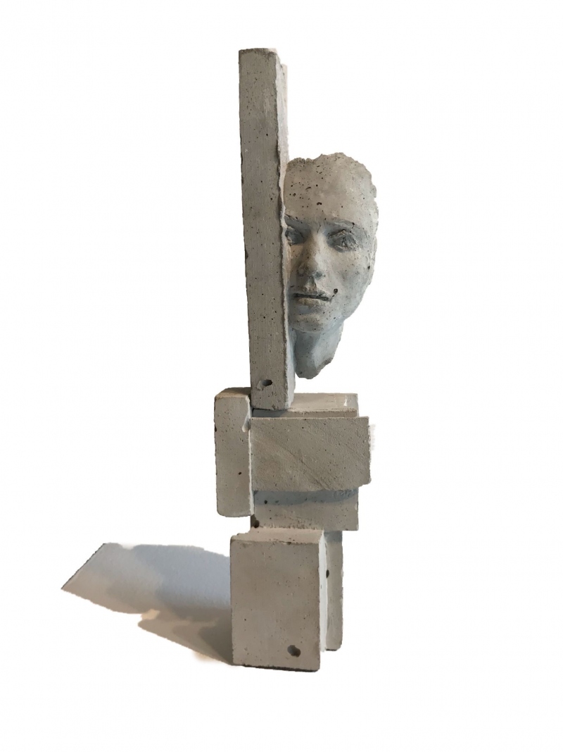 A human face sculpted amongst concrete blocks. 