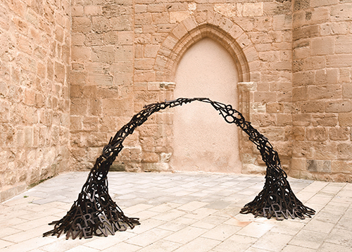 A bridge-like metal form that is a sculpture by Beatriz Diaz Ceballos. 