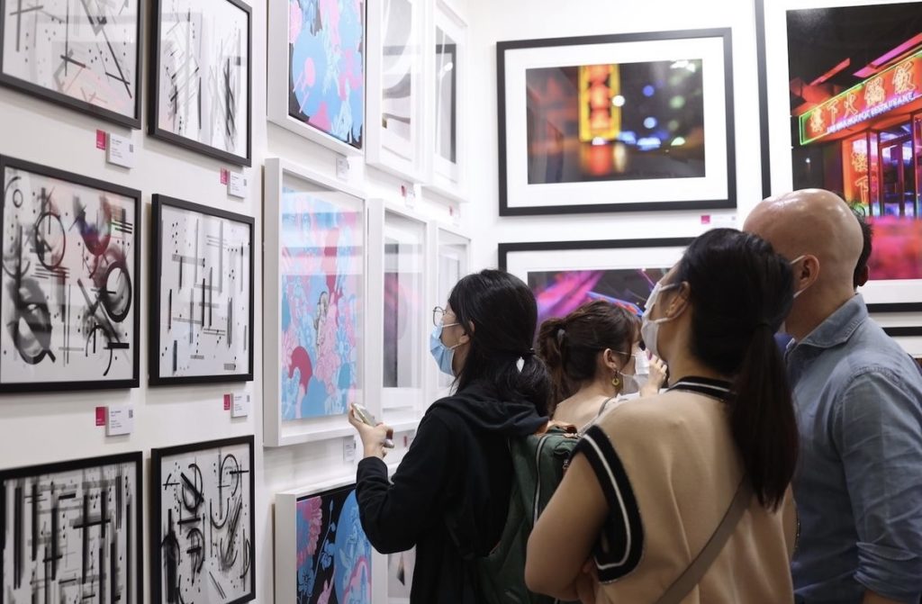 Visitors visiting artworks hanging on walls in Affordable Art Fair 2022