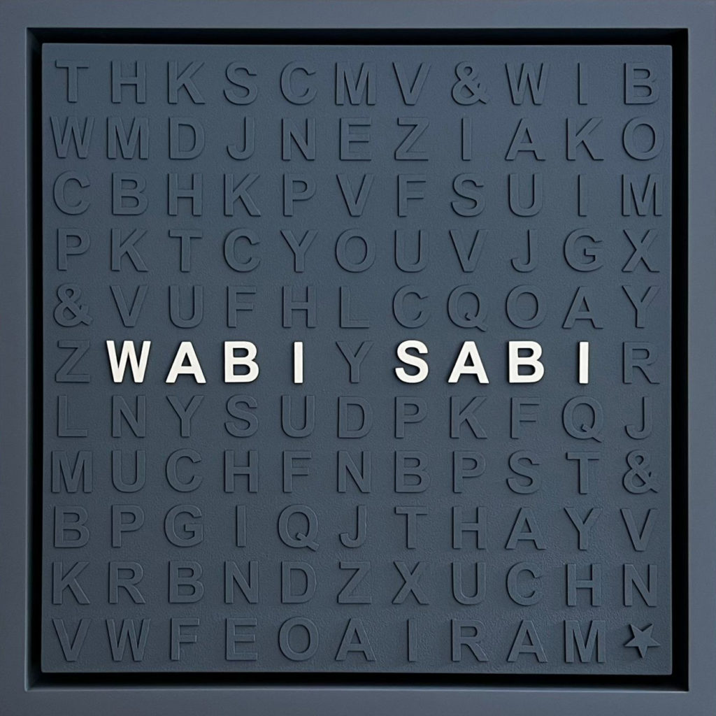 An image of a navy blue square filled with letters of the same color, except for 8 white letters that spell "wabi Sabi".