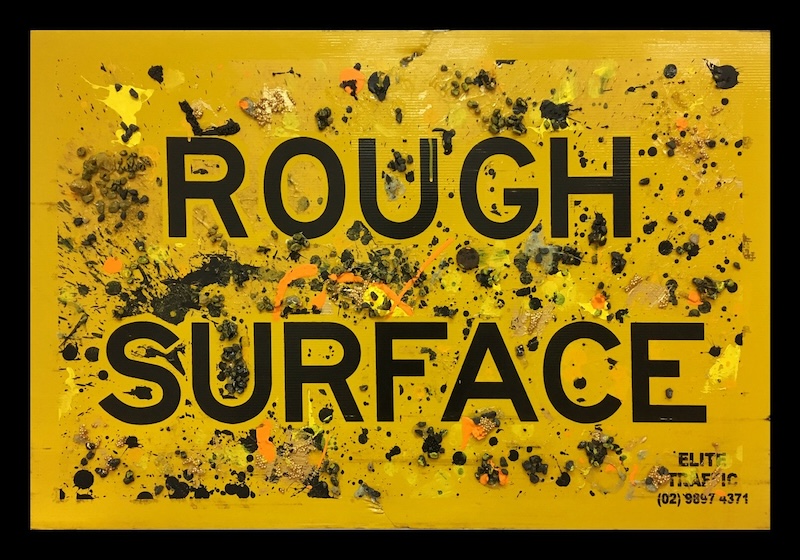 A road sign that reads 'rough surface' in black bold text. 